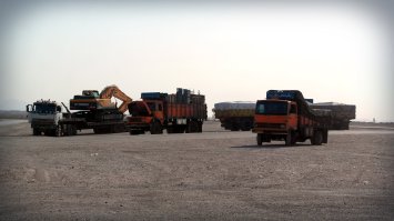 Ciężarówki na pustynnym parkingu w Jandaq